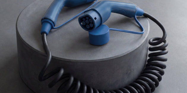Voldt® coiled EV charging cable displayed on a grey concrete plinth