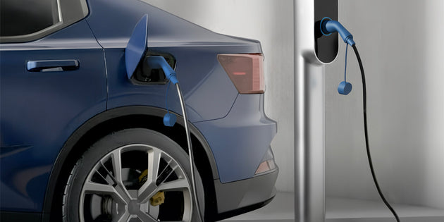 Side view of a blue electric car plugged into a silver charging pedestal indoors